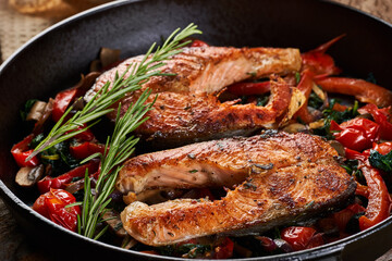 Salmon with vegetables cooked in a cast iron skillet