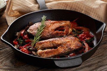 Salmon with vegetables cooked in a cast iron skillet