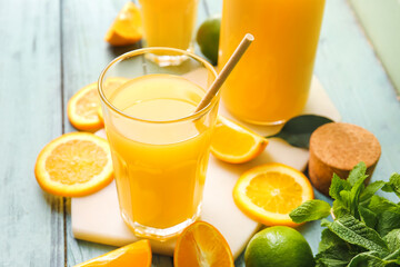 Glass of tasty orange juice on color wooden background, closeup