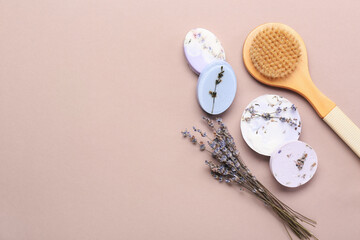 Massage brush, soap bars and lavender flowers on color background