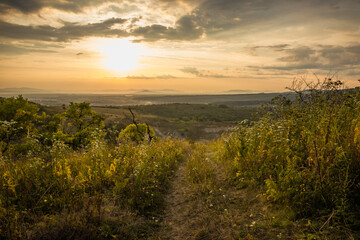 Golden sunrise in the mountains. Dawn in the mountains. The sun rises from behind the mountains. Beautiful green hills and green valley. Little sleeping town. Mountains in the fog. Carpathian, Ukraine