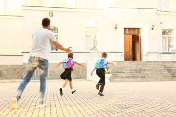 Cute little children going to school with their father
