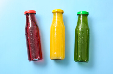 Bottles with healthy juice on color background