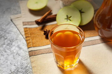 Glass of apple juice on light background