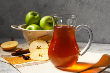 Jug of apple juice on table