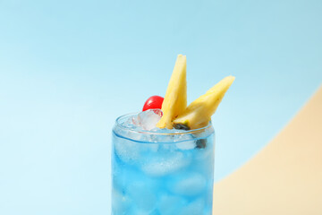 Glass of Blue Lagoon cocktail on color background
