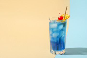Glass of Blue Lagoon cocktail on color background
