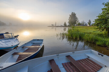 Obraz premium Early morning. Fog on the river. Beautiful sunrise in the summer by the river. boats at the pier.