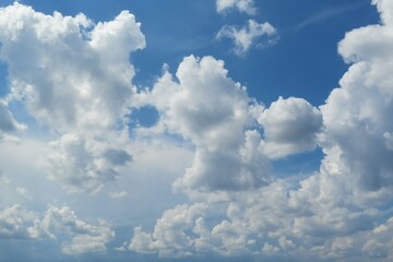 Naklejka na ściany i meble Beautiful blue sky background with white curly clouds
