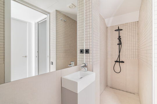 Interior Of Modern Bathroom With Beige Tiles, Shower And Small Sink