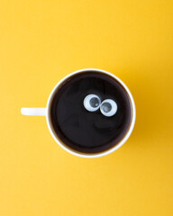 A cup of coffee with eyes.