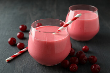 Glasses of cherry smoothie and ingredients on dark wooden table