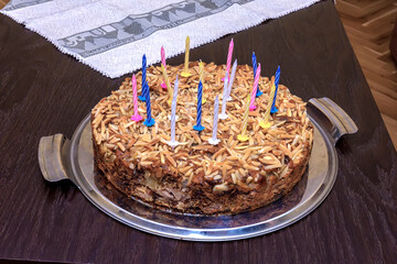 Delicious torte for birthday with candles on the table.