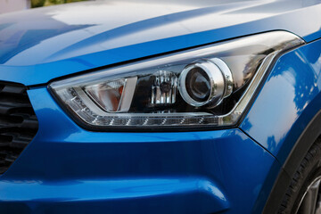 Blue passenger car in the summer parking lot close-up. fuzzy focus