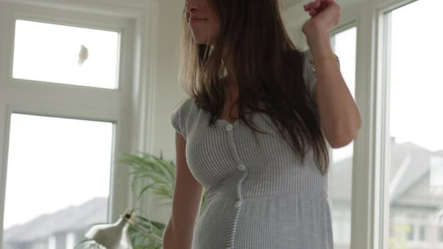 Pregnant woman - 25 weeks pregnant dancing on table in living room - having fun 5