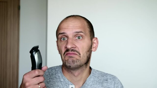 a funny man began to cut his beard, but the trimmer is broke. Oops
