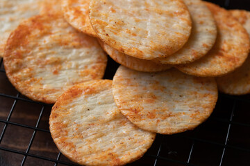 Crispy crackers on a black circle, black top view.