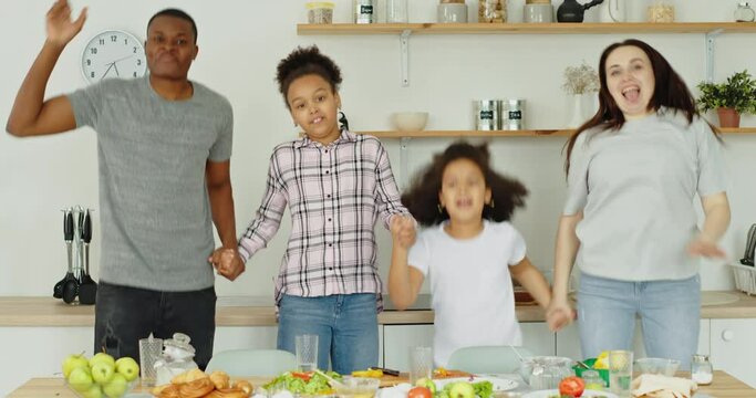 Happy mixed race family having fun in kitchen