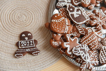 Gingerbread cookies homemade and holiday decor on table with burlap tablecloth. Celebration postcard. 