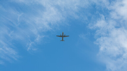 View of propeller plane flying with blue sky and clouds. Airplane fly