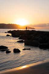 Fototapeta na wymiar Vertical photo of fisherman silouette during sunrise
