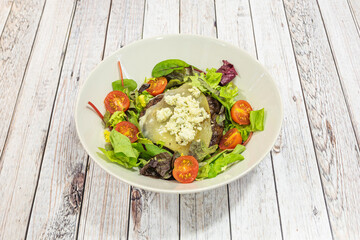 Salad with beef burger fillet with melted cheese and fresh cheese, with cherry tomatoes and oak lettuce