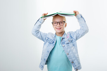 a little girl with a book on her head on a white background is isolated