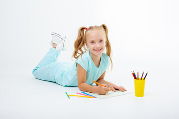 a little girl draws with pencils on a white background isolated