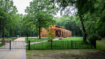 A graduation tower in a city park surrounded by greenery, a place for inhalation and recreation, a structure made of wood and blackthorn - obrazy, fototapety, plakaty