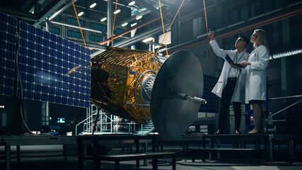 Engineer and Technician Working on Satellite Construction. Aerospace Agency: Diverse Team of...