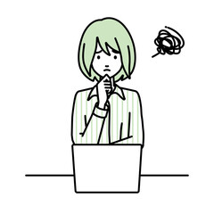 デスクで座ってPCを開いて困っているブラウスの女性