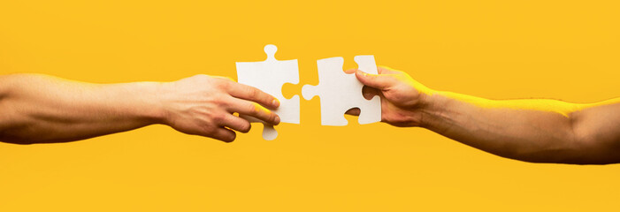 Hand connecting jigsaw puzzle. Business solutions, success and strategy concept. Man hands...