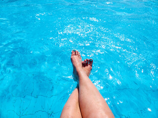 A woman's legs are crossed over the pool