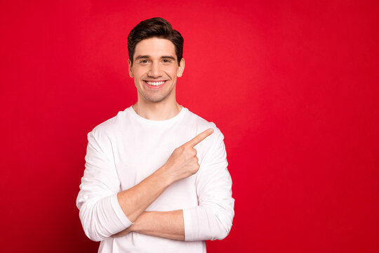 Photo Portrait Brunet Guy In White Shirt Blue Jeans Confident Smiling Showing Copyspace Isolated Vivid Red Color Background