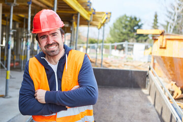 Bauarbeiter mit Schutzhelm auf Rohbau der Baustelle