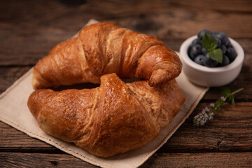 Fresh homemade croissants on wooden table