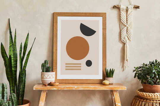 Creative composition of stylish living room interior with mock up poster frame, wooden bench, rattan basket, cacti and boho accessories. Plant love and nature concept. Template.