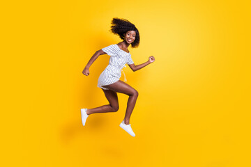 Fototapeta na wymiar Full length body size view of attractive cheerful motivated girl jumping running fast isolated over bright yellow color background