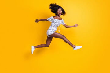 Fototapeta na wymiar Full length body size view of attractive cheerful crazy childish comic girl jumping running isolated over bright yellow color background