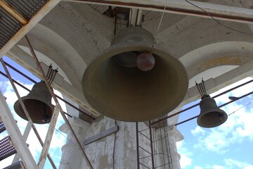 Three metal bells suspended in the bell tower.