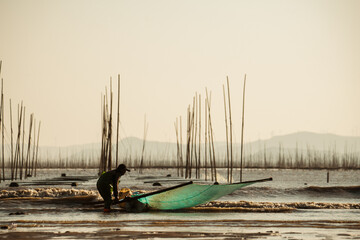 Fisherman walking across the mudflats to catch marine life 