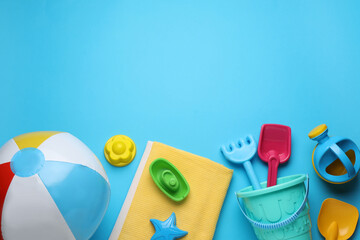 Flat lay composition with beach ball and sand toys on light blue background, space for text