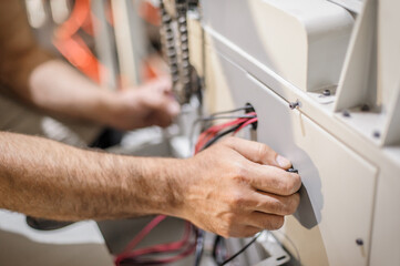 Close up of electrician engineer works with electric cable wires. Installation inspect. Electrical equipment