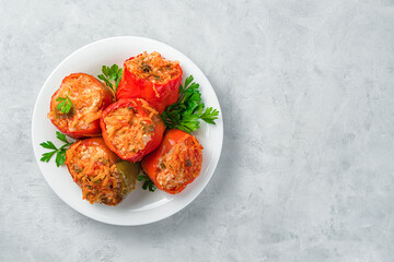 Stewed bell pepper with turkey, rice and vegetables on a gray background.