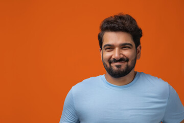 Portrait of a man smiling against plain backdrop.