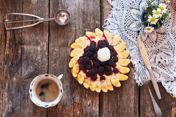 Obraz na płótnie Canvas blackberry flower pie on a wooden table. Flowers, coffee, shortcrust pastry, ricotta, ice cream, chamomile, top view.