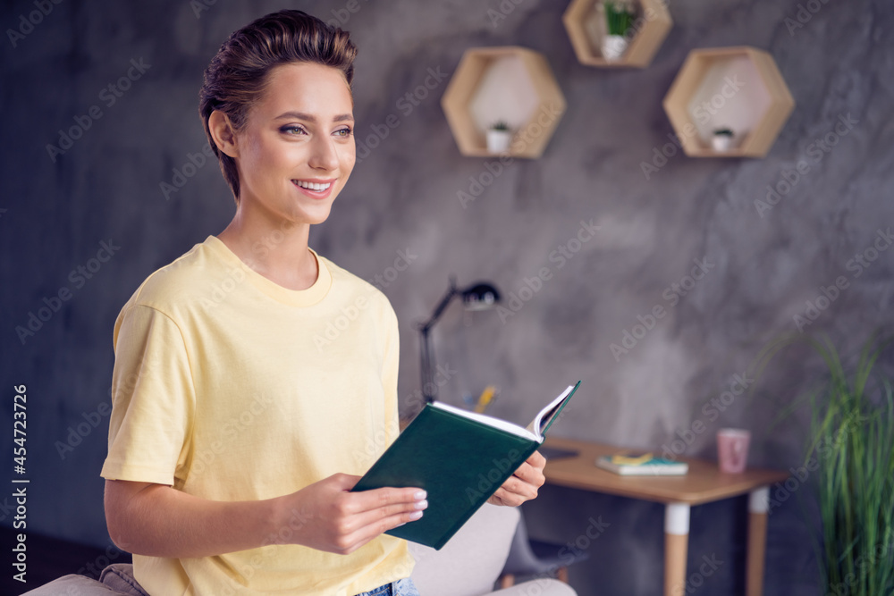 Poster Photo of happy positive pretty nice young woman hold hand novel book smile indoors inside house home apartment