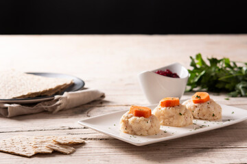 Traditional Jewish gefilte fish and matzah bread on wooden table