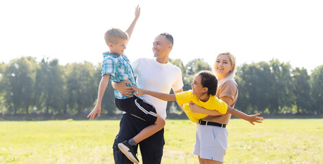 Obraz premium Happy family walking in field and holding hands