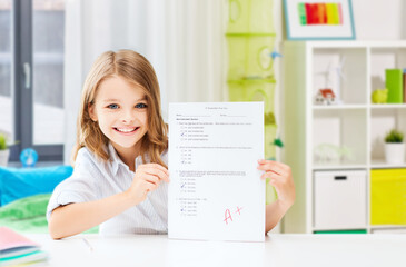education and school concept - happy smiling student girl with school test and A grade over home room background